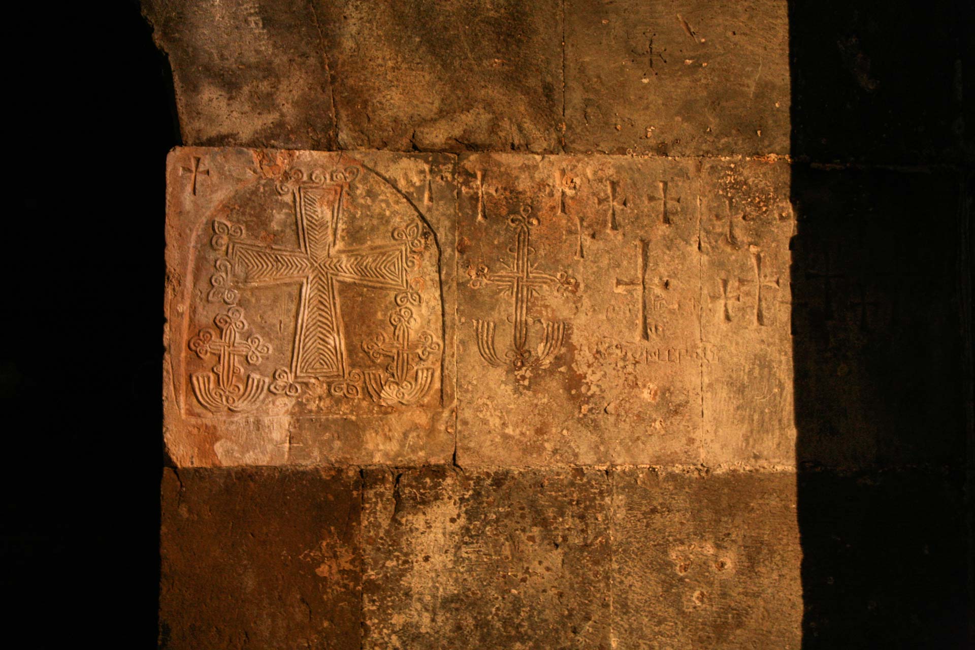 Kreuzzeichnungen auf den Sandsteinmauern des Klosters Varak.